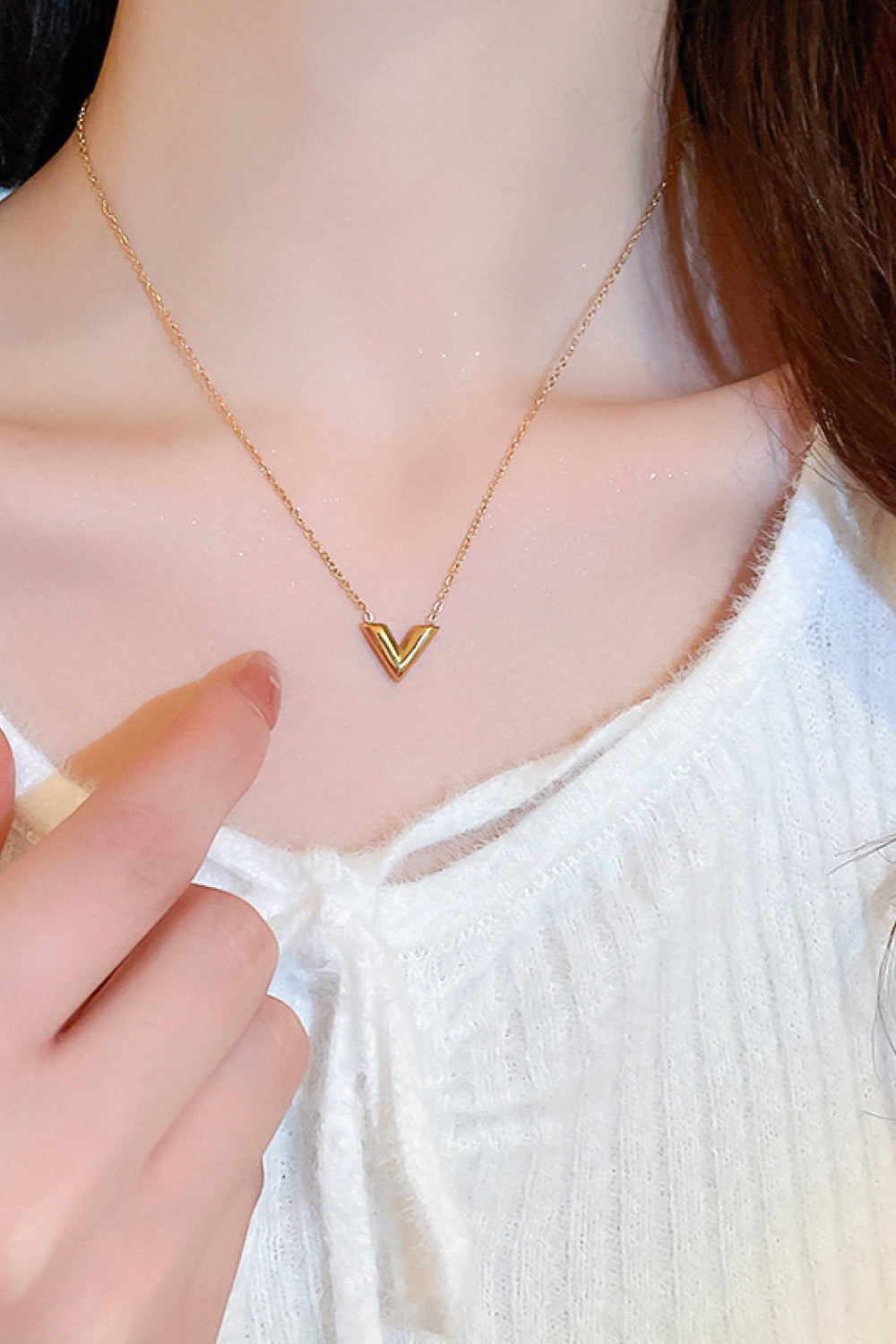 A delicate 18K gold plated V pendant necklace on a white background, showcasing its minimalist design and polished finish.