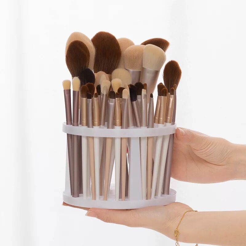 A sleek and polished plastic makeup brush storage stand, designed to hold various sizes of brushes securely and stylishly.