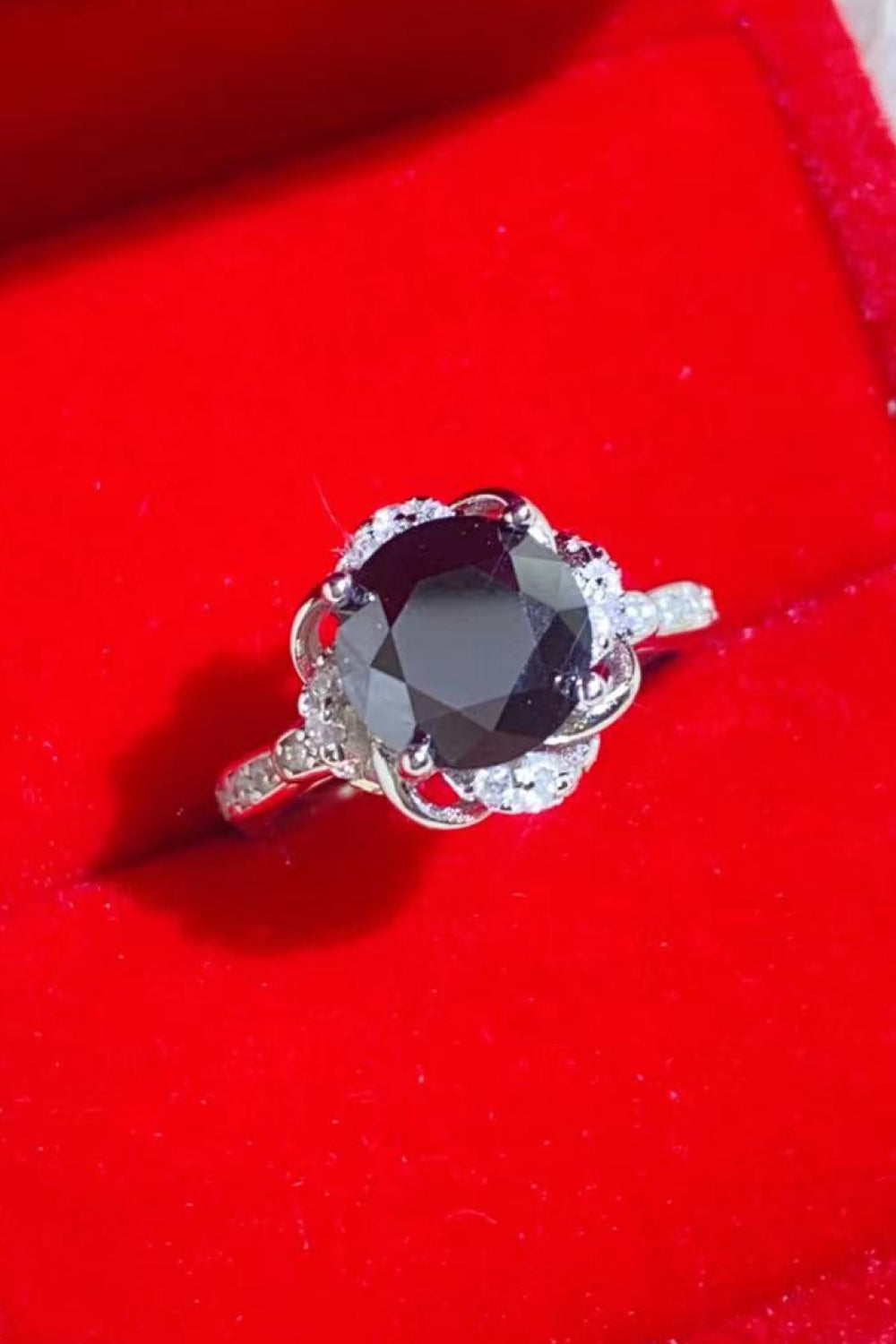 A beautiful 2 Carat Black Moissanite Floral Ring displayed in a flat lay style, showcasing its modern minimalist design and sparkling moissanite stone.