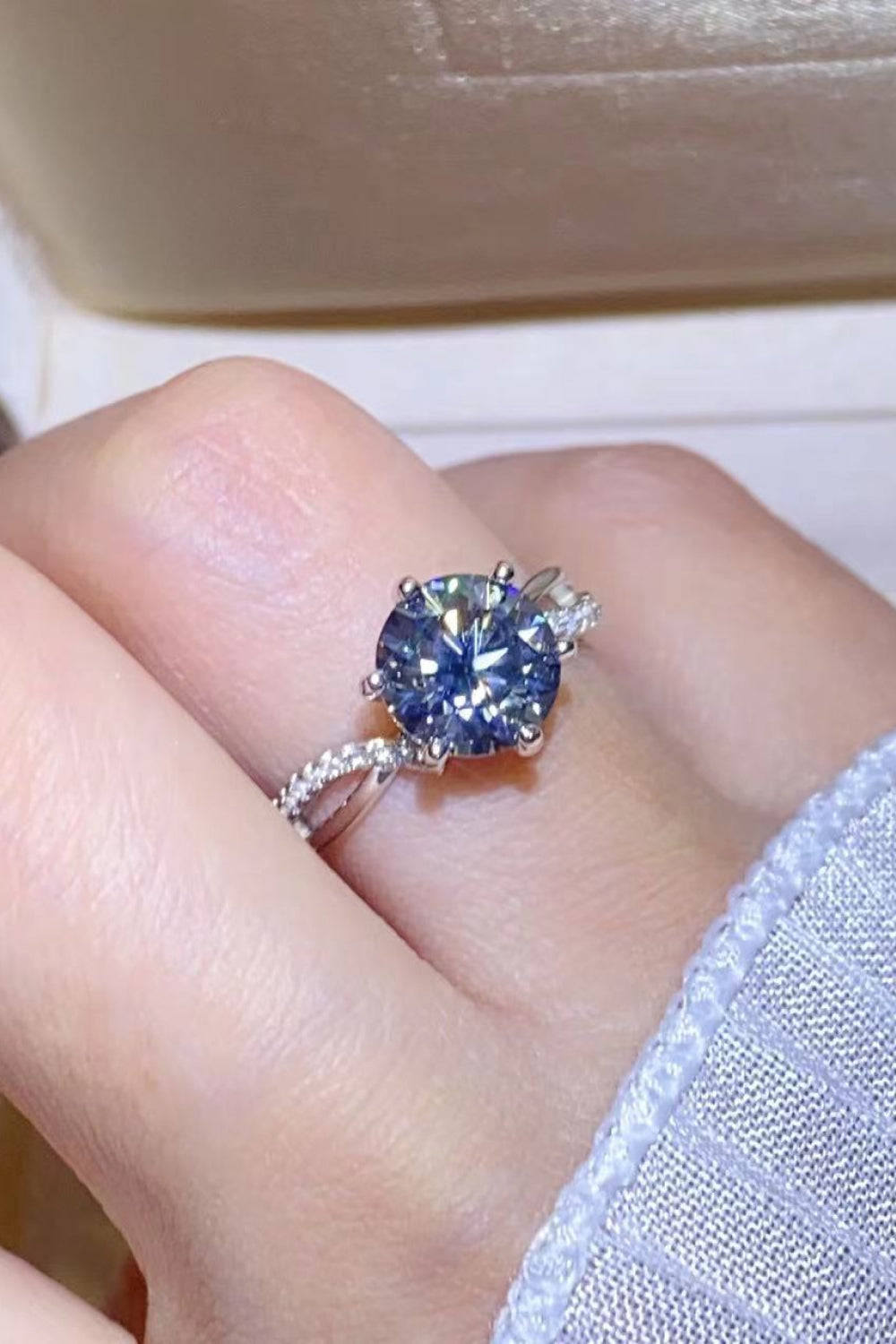 A stunning 2 Carat Moissanite Ring in Smokey Gray, featuring a round moissanite stone set in polished 925 sterling silver, displayed in a studio flat lay.