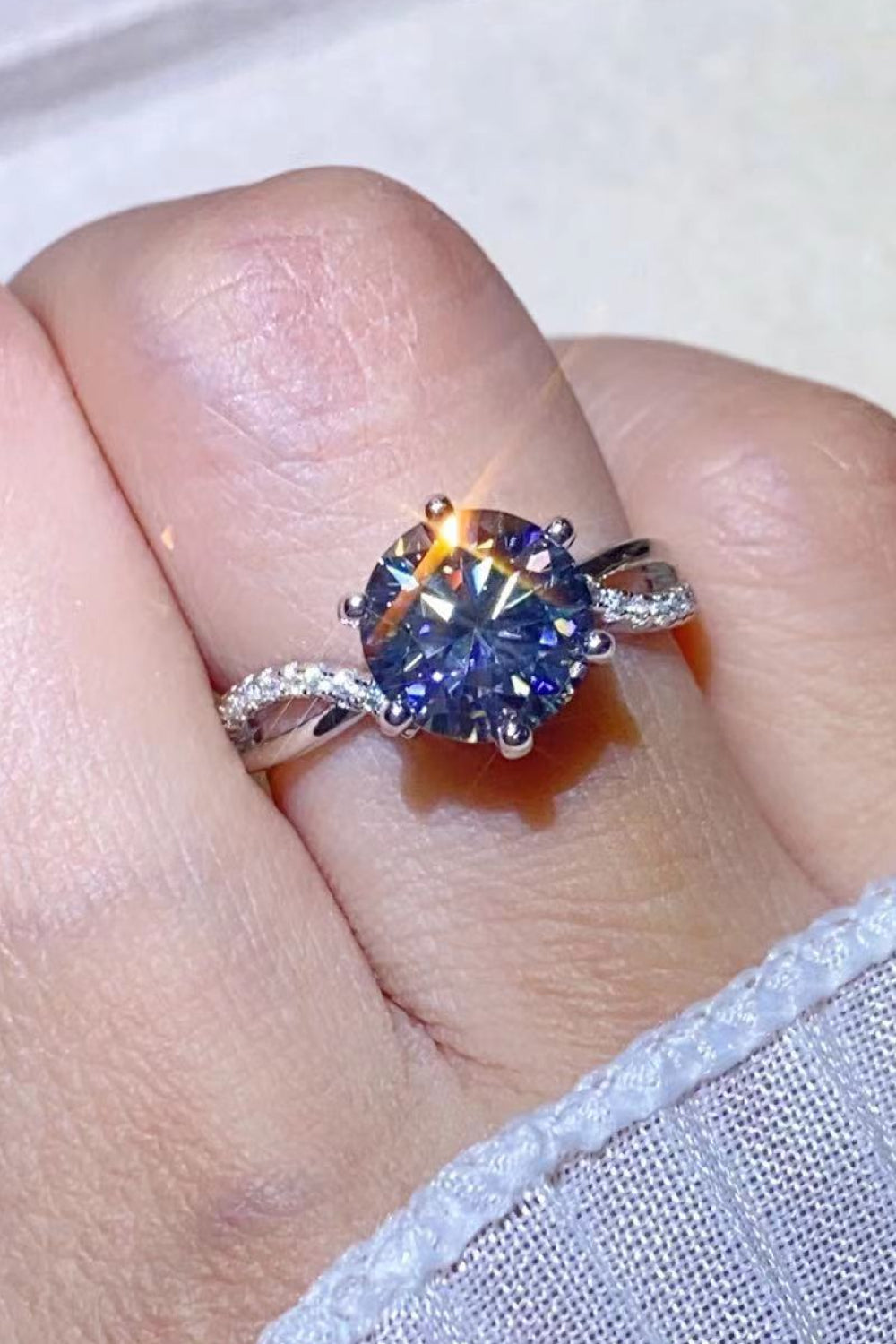 A stunning 2 Carat Moissanite Ring in Smokey Gray, featuring a round moissanite stone set in polished 925 sterling silver, displayed in a studio flat lay.