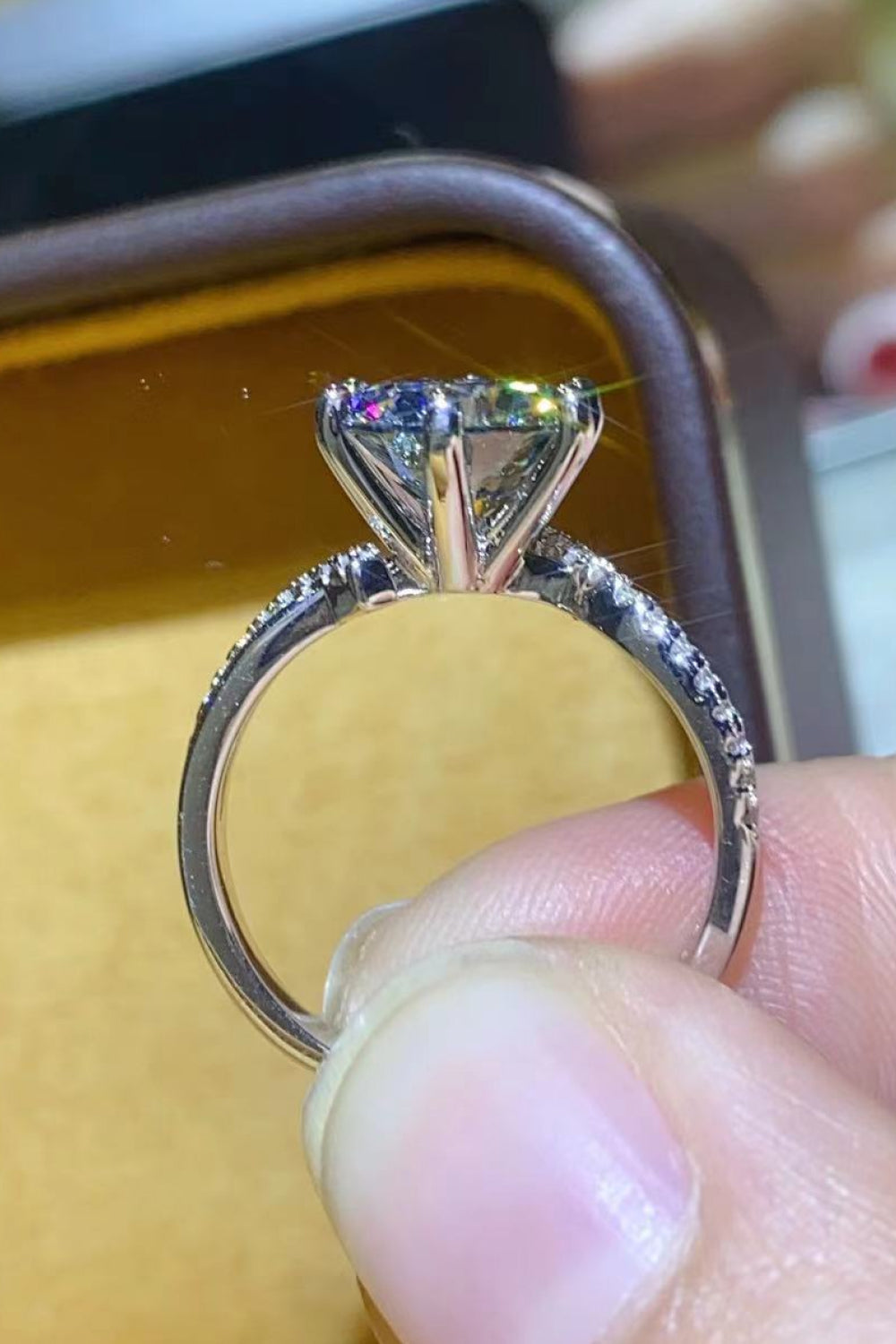 A stunning 2 Carat Moissanite Ring in Smokey Gray, featuring a round moissanite stone set in polished 925 sterling silver, displayed in a studio flat lay.