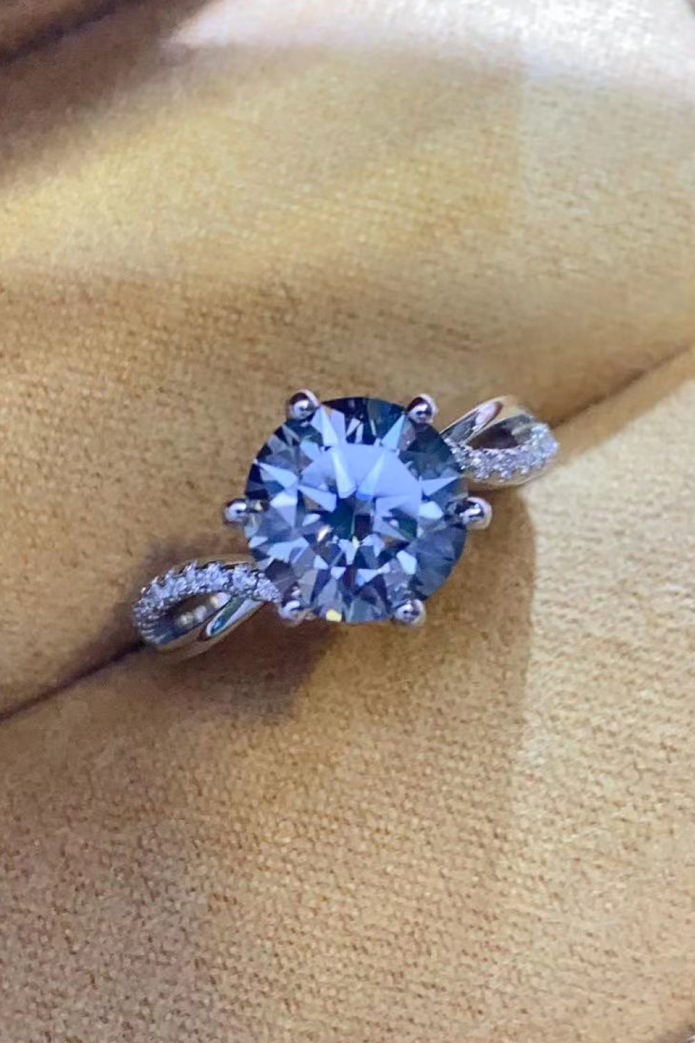 A stunning 2 Carat Moissanite Ring in Smokey Gray, featuring a round moissanite stone set in polished 925 sterling silver, displayed in a studio flat lay.