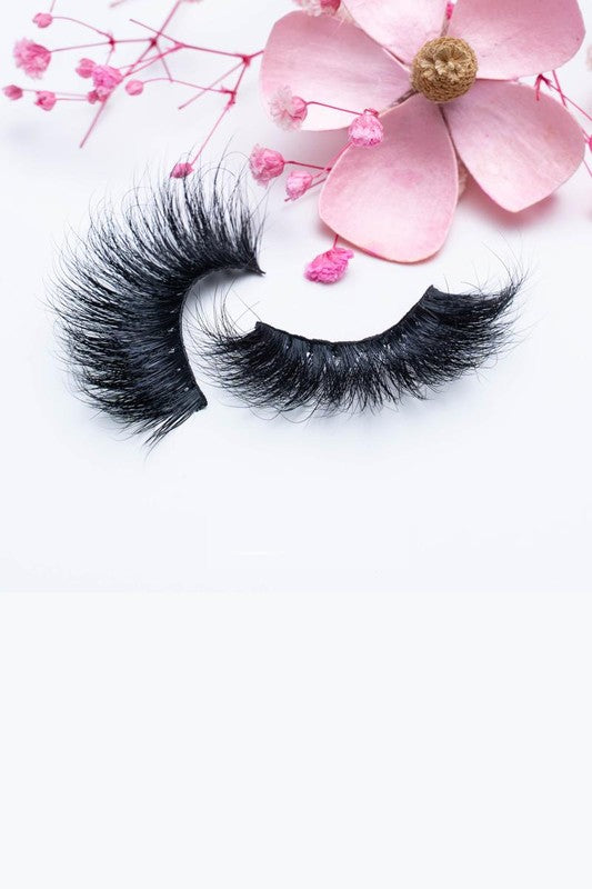 A pair of 25mm dramatic volume mink eyelashes displayed in elegant packaging, showcasing their fluffy texture and round eye shape.