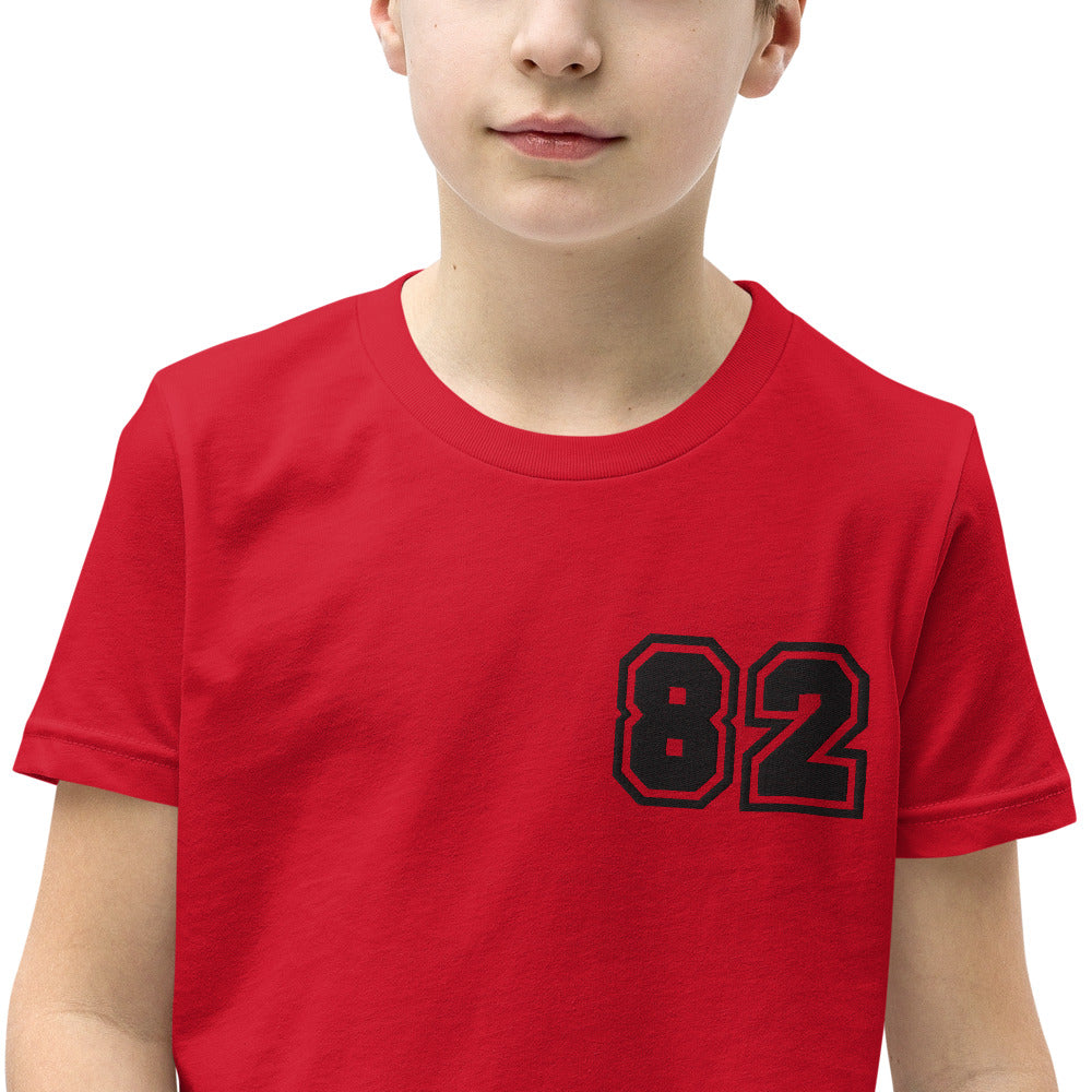 A youth wearing the 2882Junior™ Greeky Prepster '82' Short Sleeve T-Shirt, showcasing its unique design and relaxed fit.