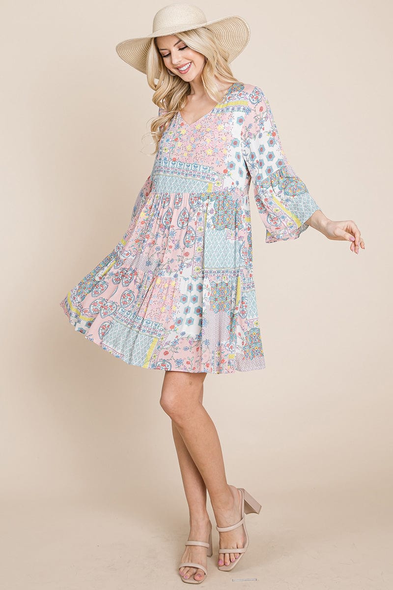 A stylish 3/4 sleeve pleated floral flowy boho swing dress, featuring a V-neck and vibrant floral patterns, perfect for various occasions.