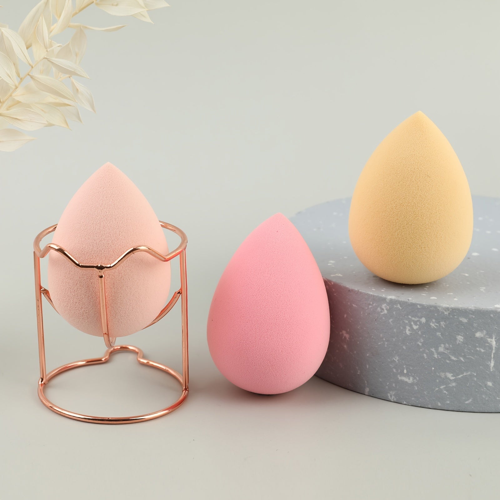 A set of four beauty blenders in various shapes and colors, designed for flawless makeup application.