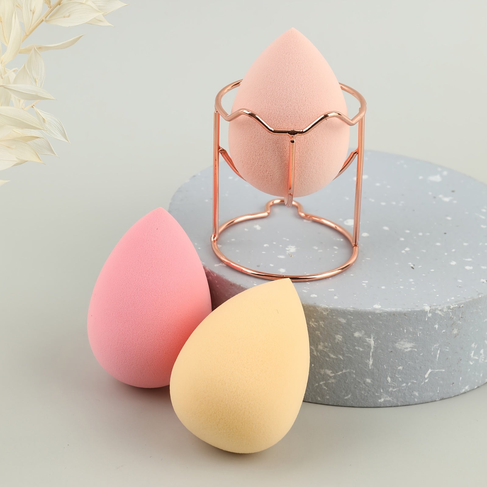 A set of four beauty blenders in various shapes and colors, designed for flawless makeup application.