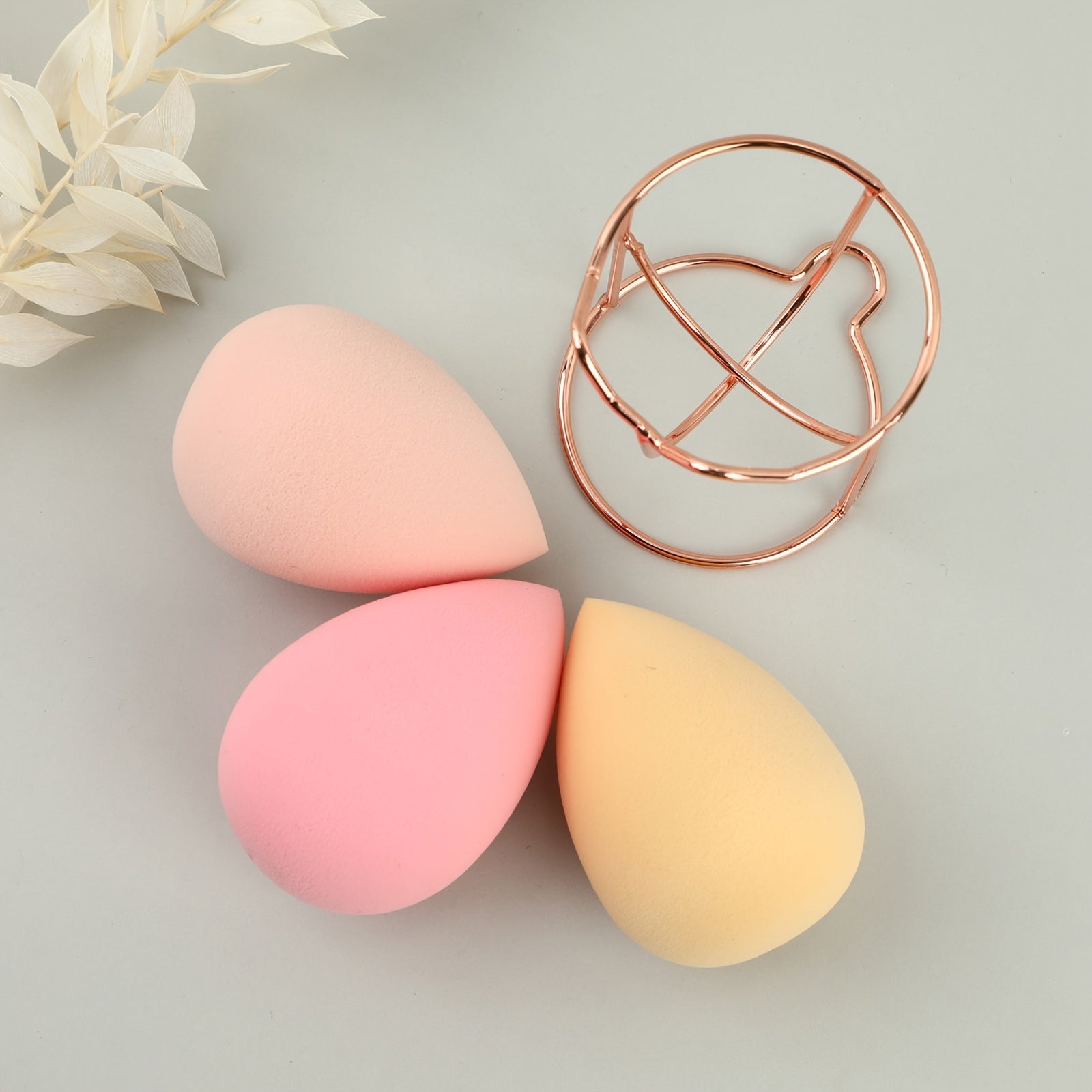 A set of four beauty blenders in various shapes and colors, designed for flawless makeup application.