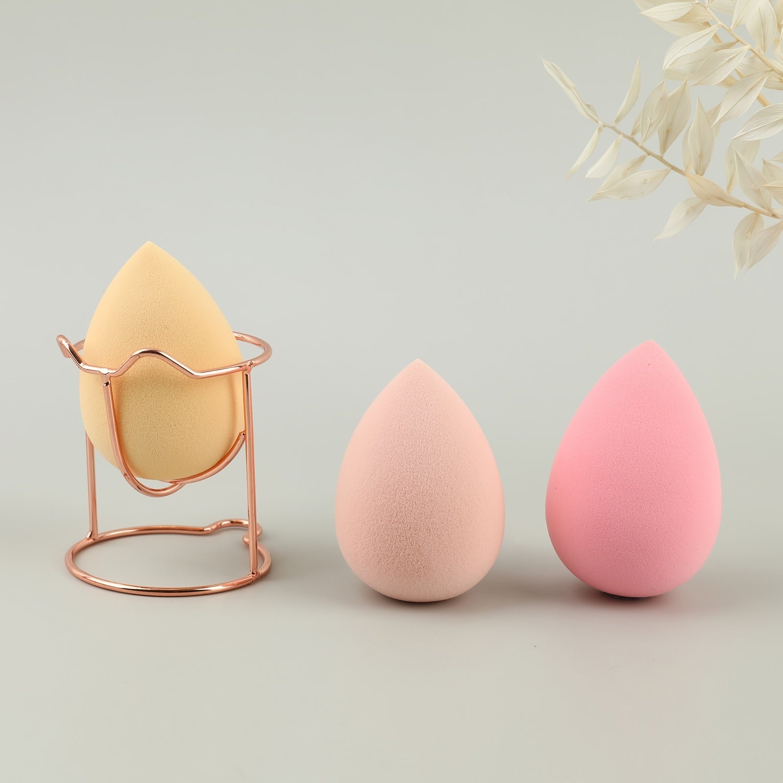 A set of four beauty blenders in various shapes and colors, designed for flawless makeup application.