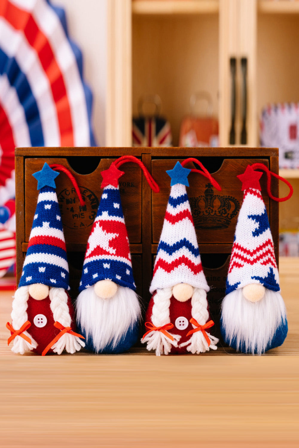 Four colorful Independence Day knit hanging gnomes, each with unique designs, perfect for festive decor.