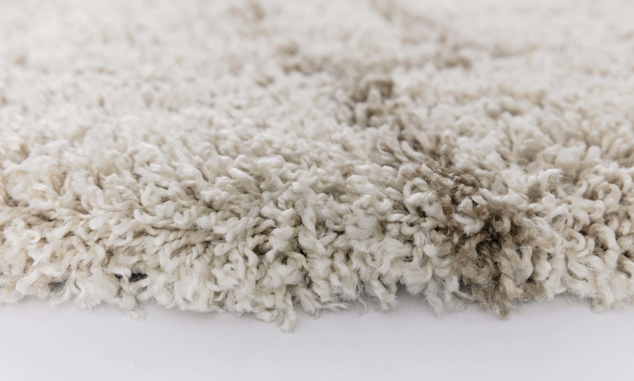 A 63" X 91" X 2" Natural Polypropylene Rug featuring a soft shag texture and neutral colors, perfect for enhancing home decor.