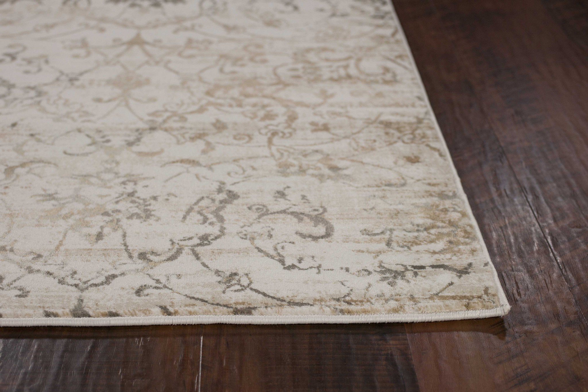 7'x10' beige machine woven floral area rug with hi/lo patterns and soft sheen highlights, perfect for indoor use.