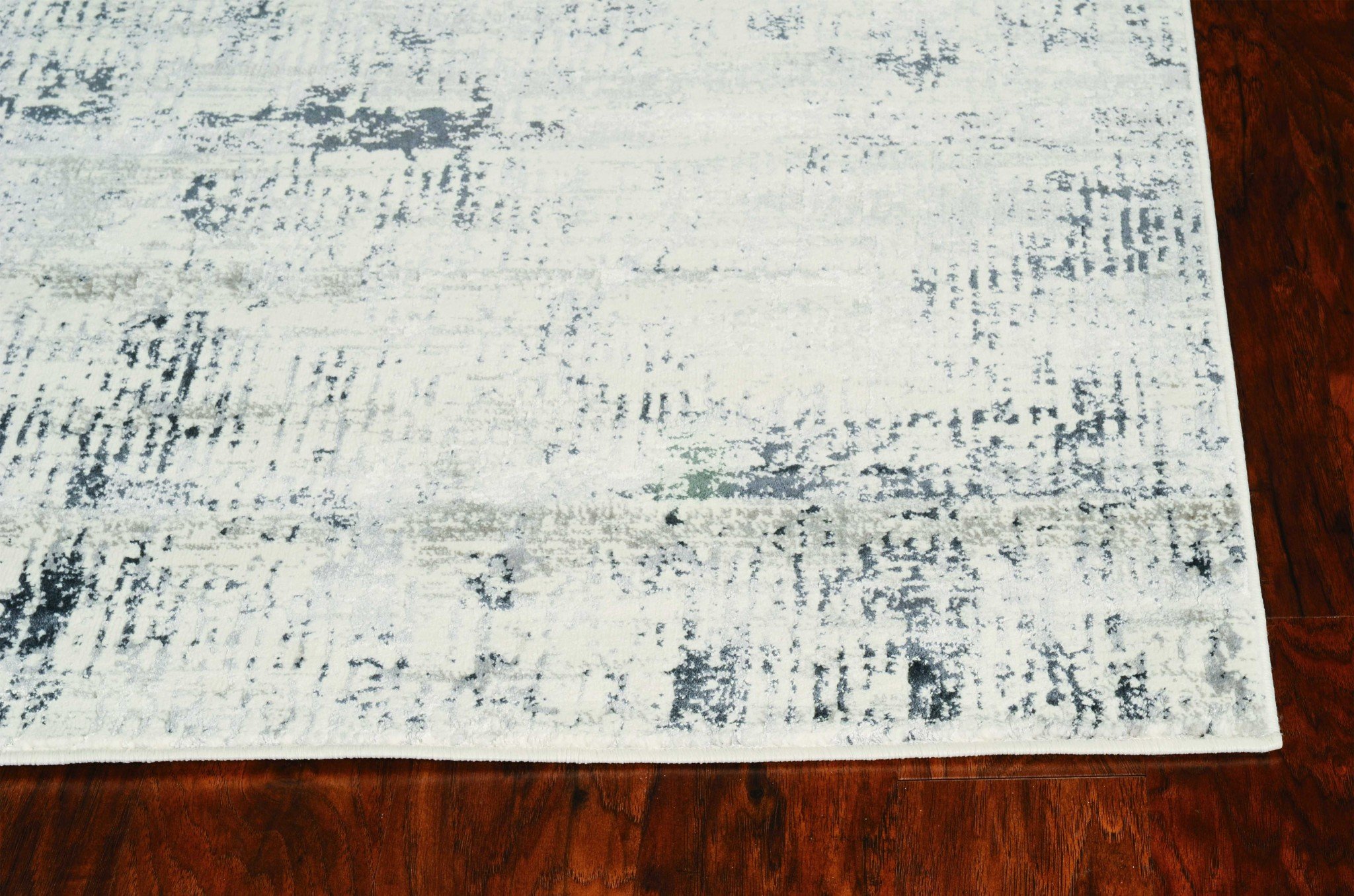 7'x10' Ivory Silver Machine Woven Abstract Scratch Indoor Area Rug with hi/lo patterns and soft sheen highlights.