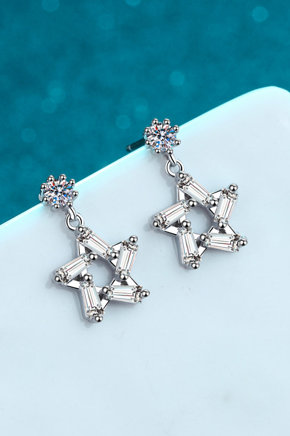 Elegant 925 sterling silver earrings featuring inlaid moissanite stones in a star design, polished finish.