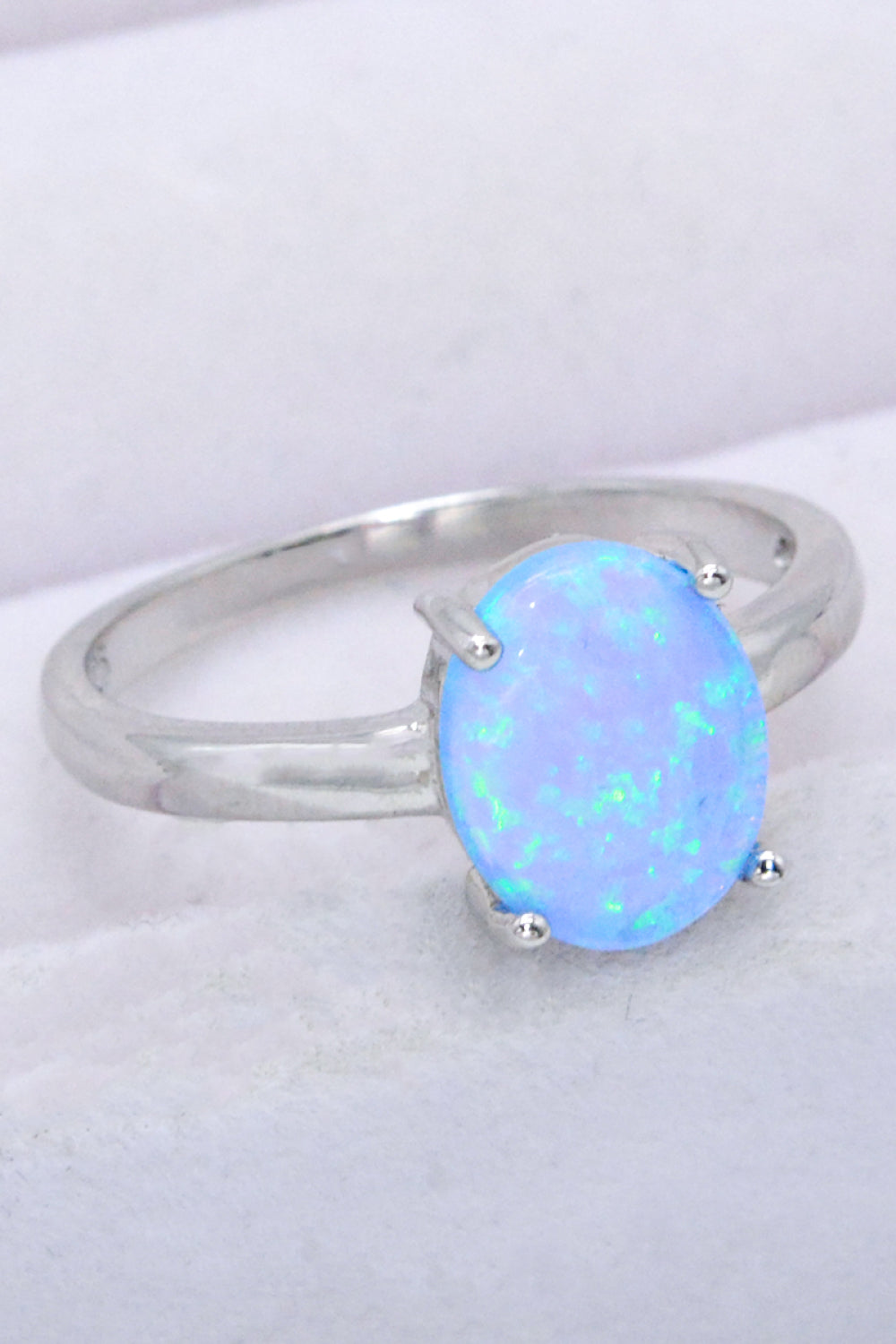 A minimalist 925 sterling silver opal solitaire ring with a polished finish, showcasing a vibrant opal gemstone.