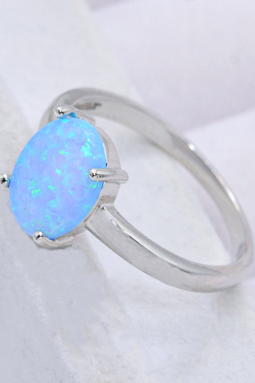 A minimalist 925 sterling silver opal solitaire ring with a polished finish, showcasing a vibrant opal gemstone.