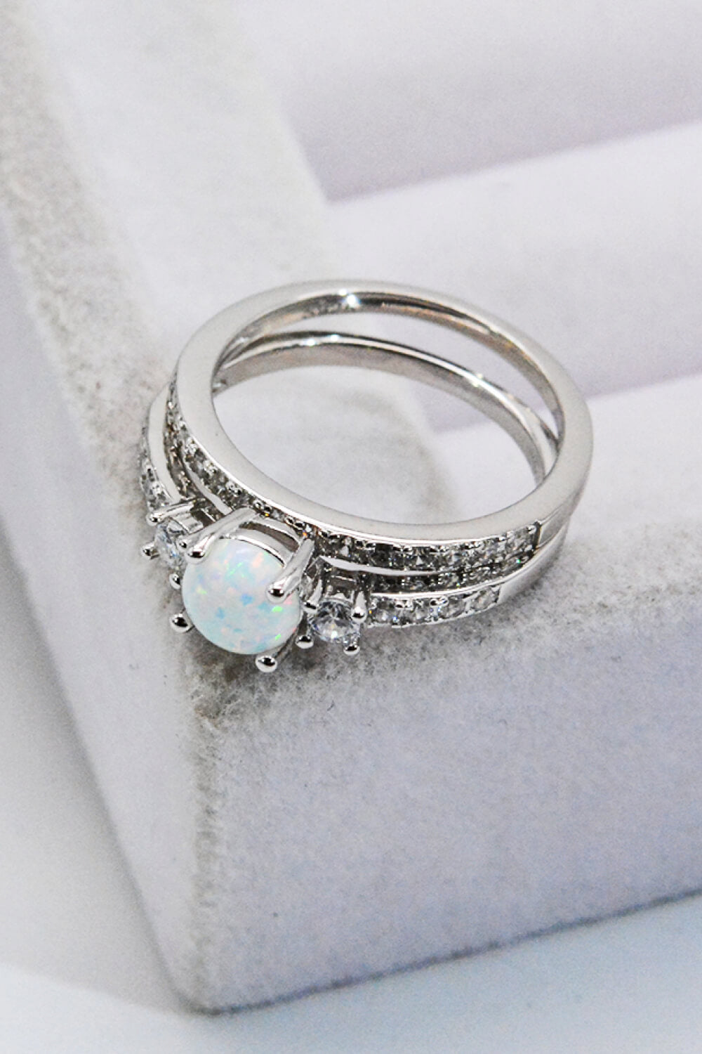 A modern 925 sterling silver opal split shank ring displayed in a flat lay style, showcasing its minimalist design and polished finish.