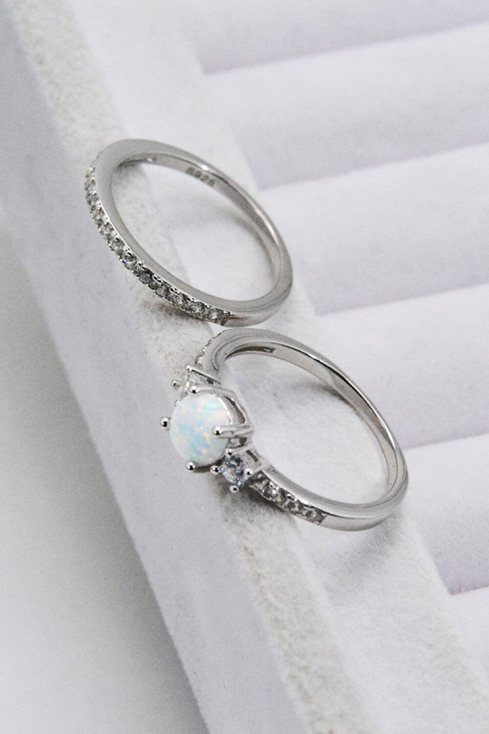 A modern 925 sterling silver opal split shank ring displayed in a flat lay style, showcasing its minimalist design and polished finish.