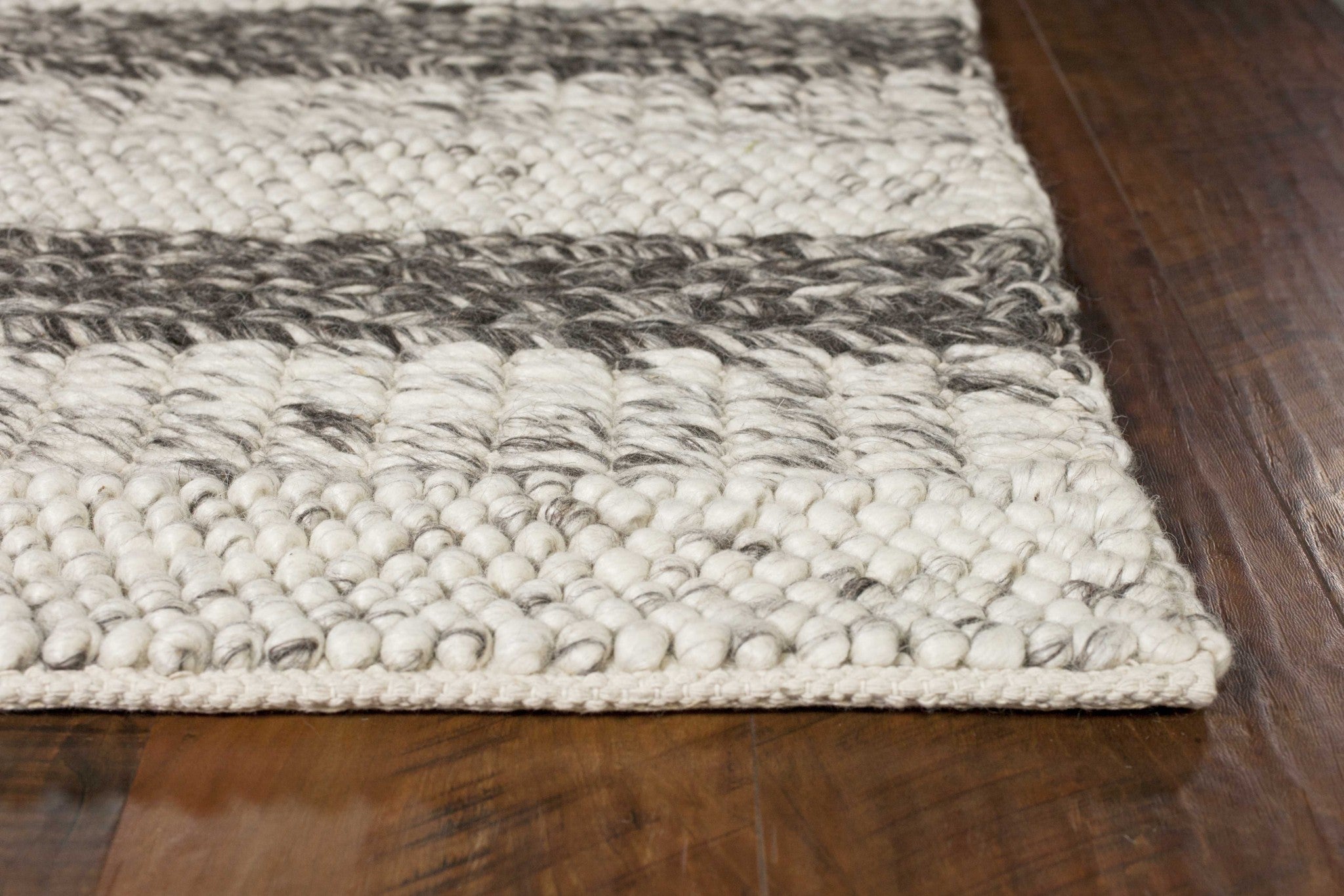 A luxurious 9x13 inches wool area rug in grey and white, showcasing a soft and nobby texture, perfect for contemporary home decor.