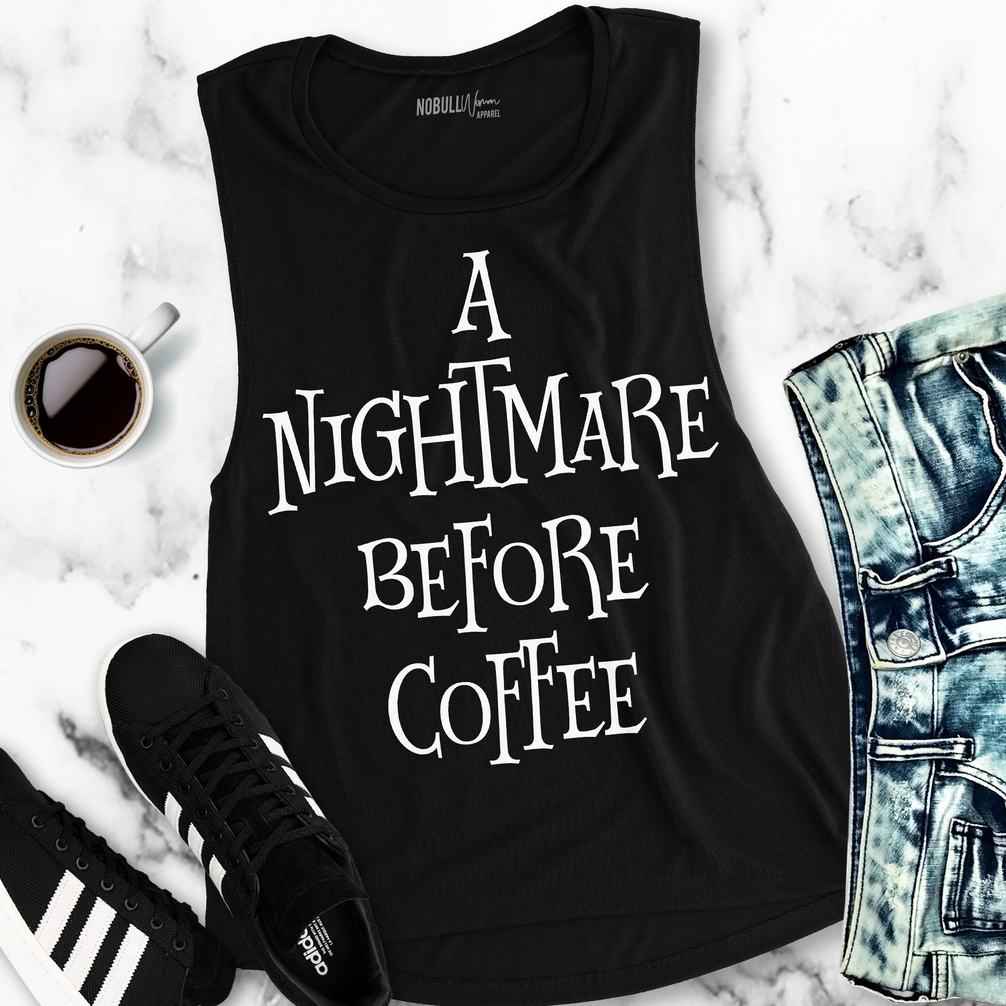 A black muscle tank top featuring the phrase 'A NIGHTMARE BEFORE COFFEE' in a fun Halloween-themed design.