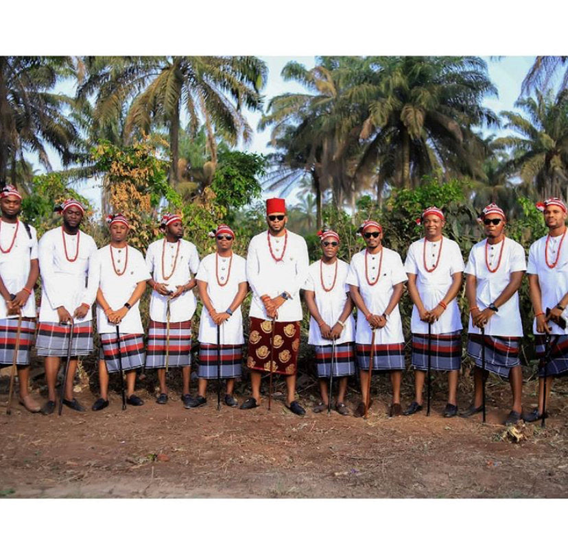 A complete set of African Groomsmen Attire including a shirt, wrapper, hat, necklace, bracelet, linking button stud, and staff, showcasing vibrant colors and traditional design.