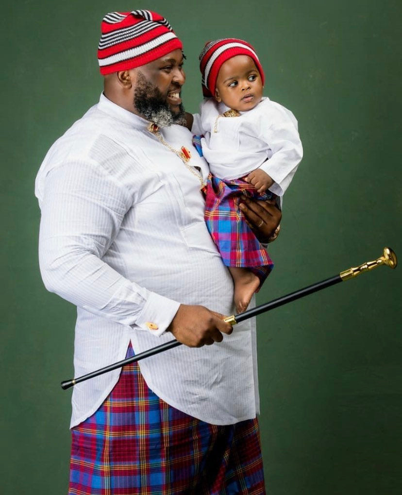 A complete set of African Groomsmen Attire including a shirt, wrapper, hat, necklace, bracelet, linking button stud, and staff, showcasing vibrant colors and traditional design.