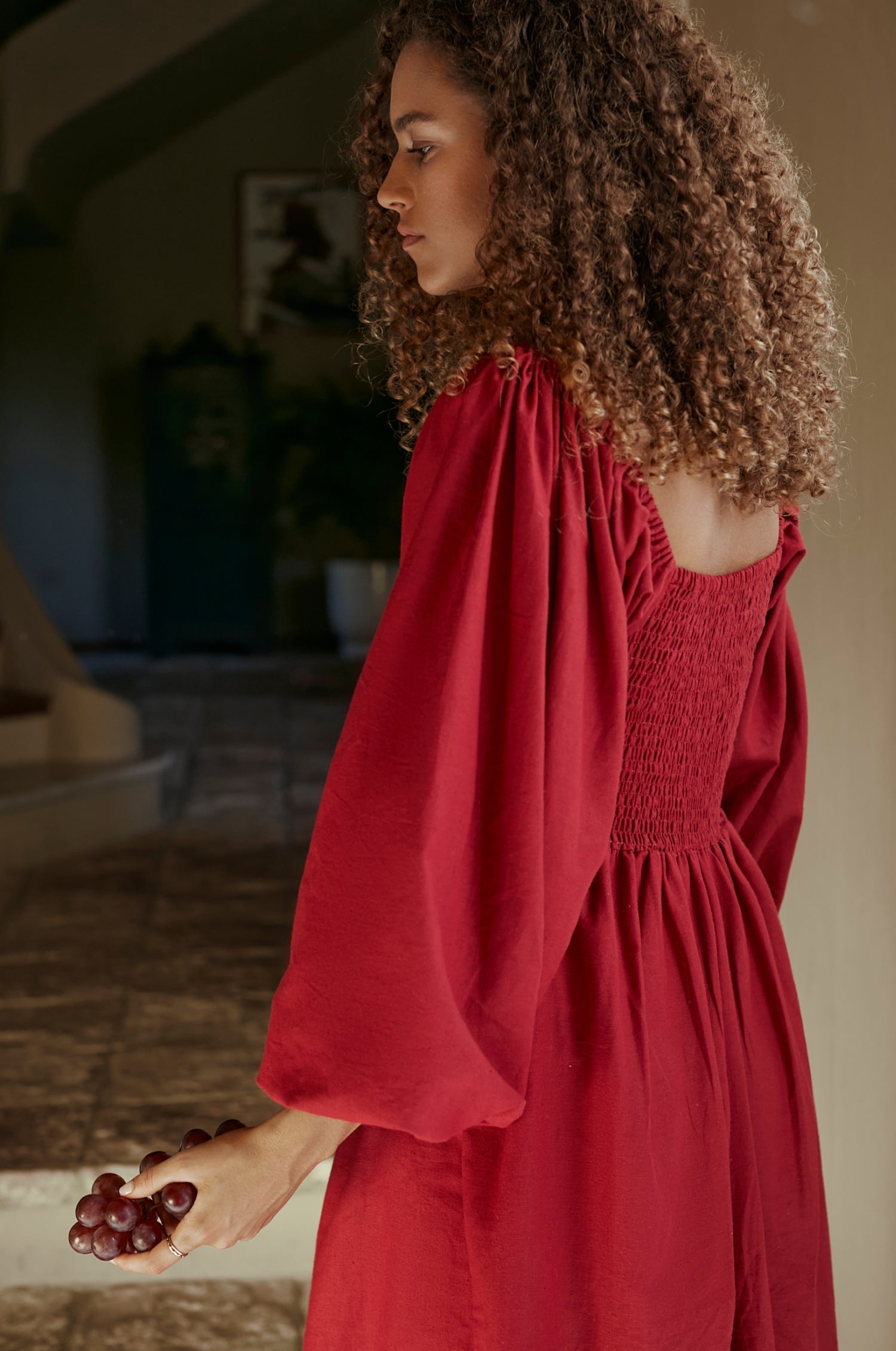 Alila Smocked Linen Midi Dress featuring a smocked bodice, gathered puff sleeves, and an oval neckline, made from 100% pure linen.