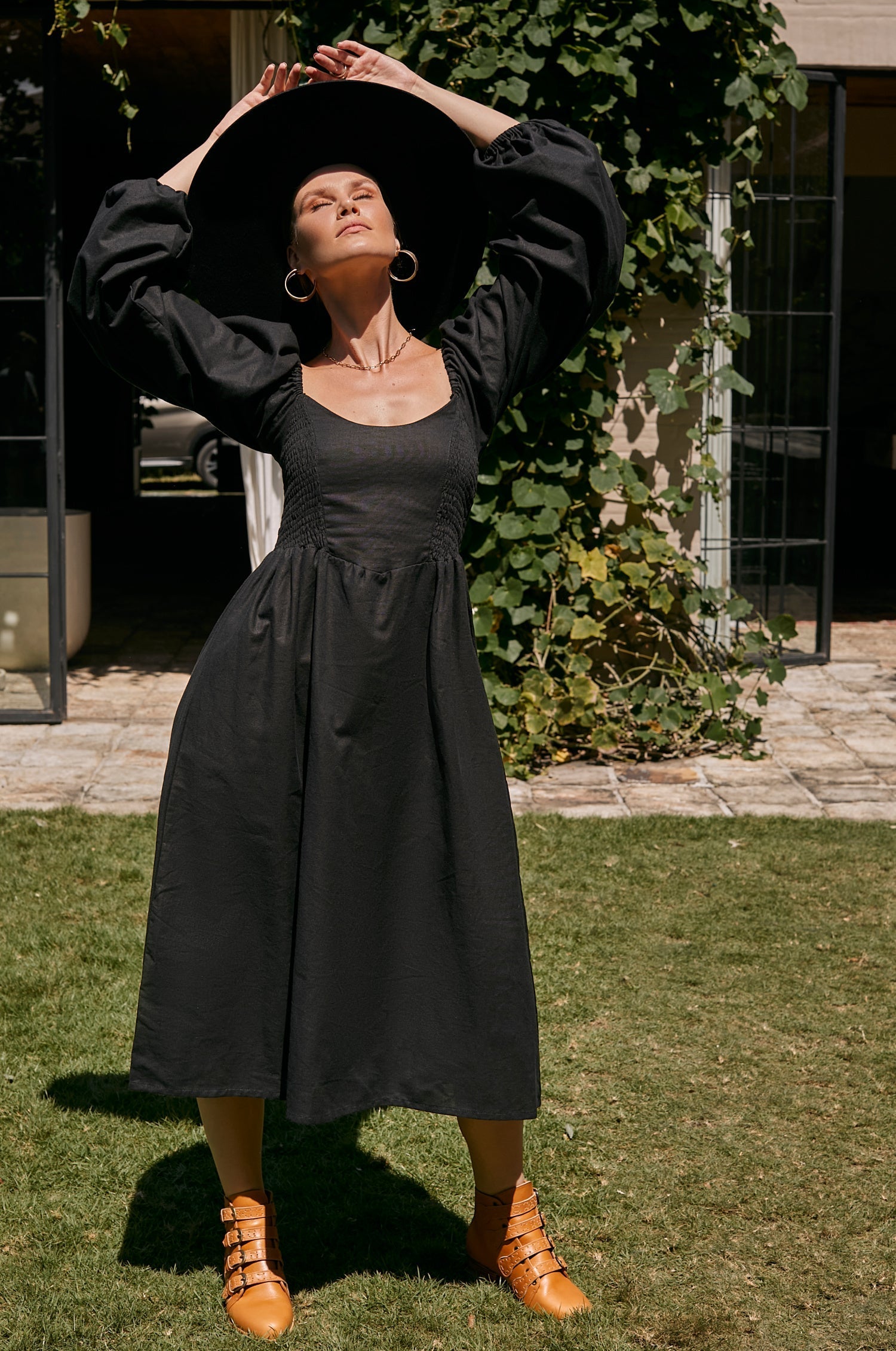 Alila Smocked Linen Midi Dress featuring a smocked bodice, gathered puff sleeves, and an oval neckline, made from 100% pure linen.