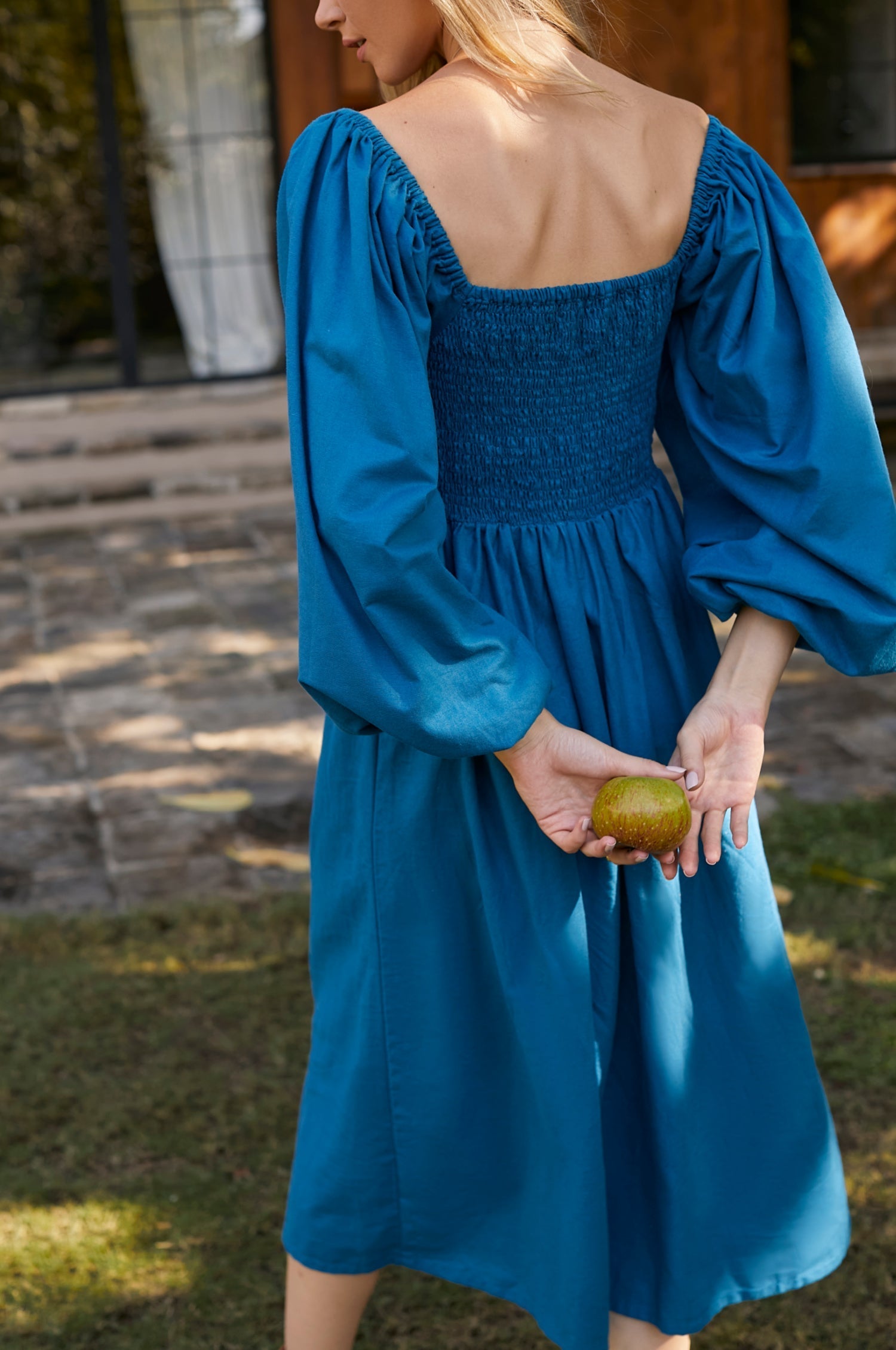 Alila Smocked Linen Midi Dress featuring a smocked bodice, gathered puff sleeves, and an oval neckline, made from 100% pure linen.