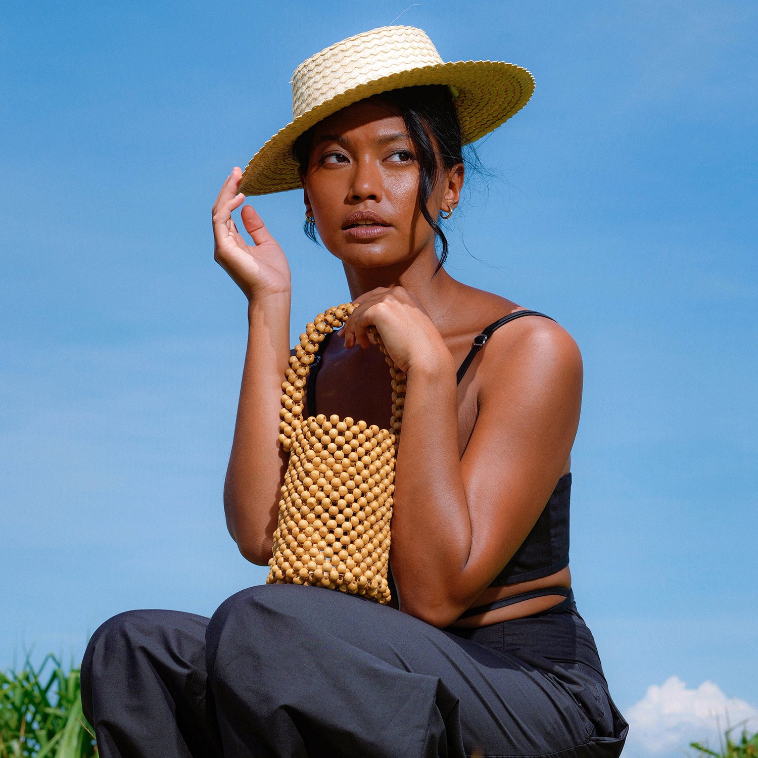 ALILA Wooden Beads Bucket Bag featuring natural wooden beads and a cotton lining, perfect for beach outings.