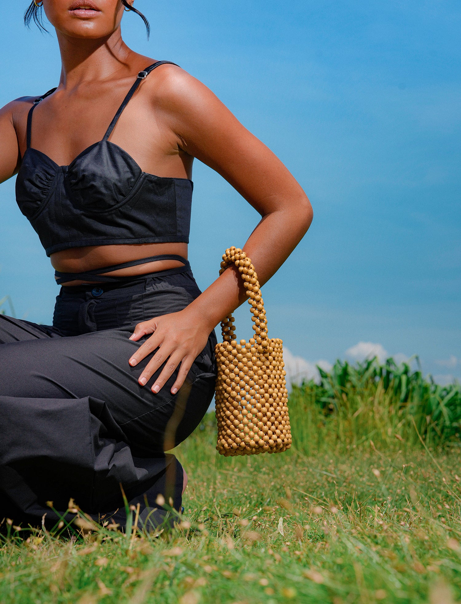 ALILA Wooden Beads Bucket Bag featuring natural wooden beads and a cotton lining, perfect for beach outings.