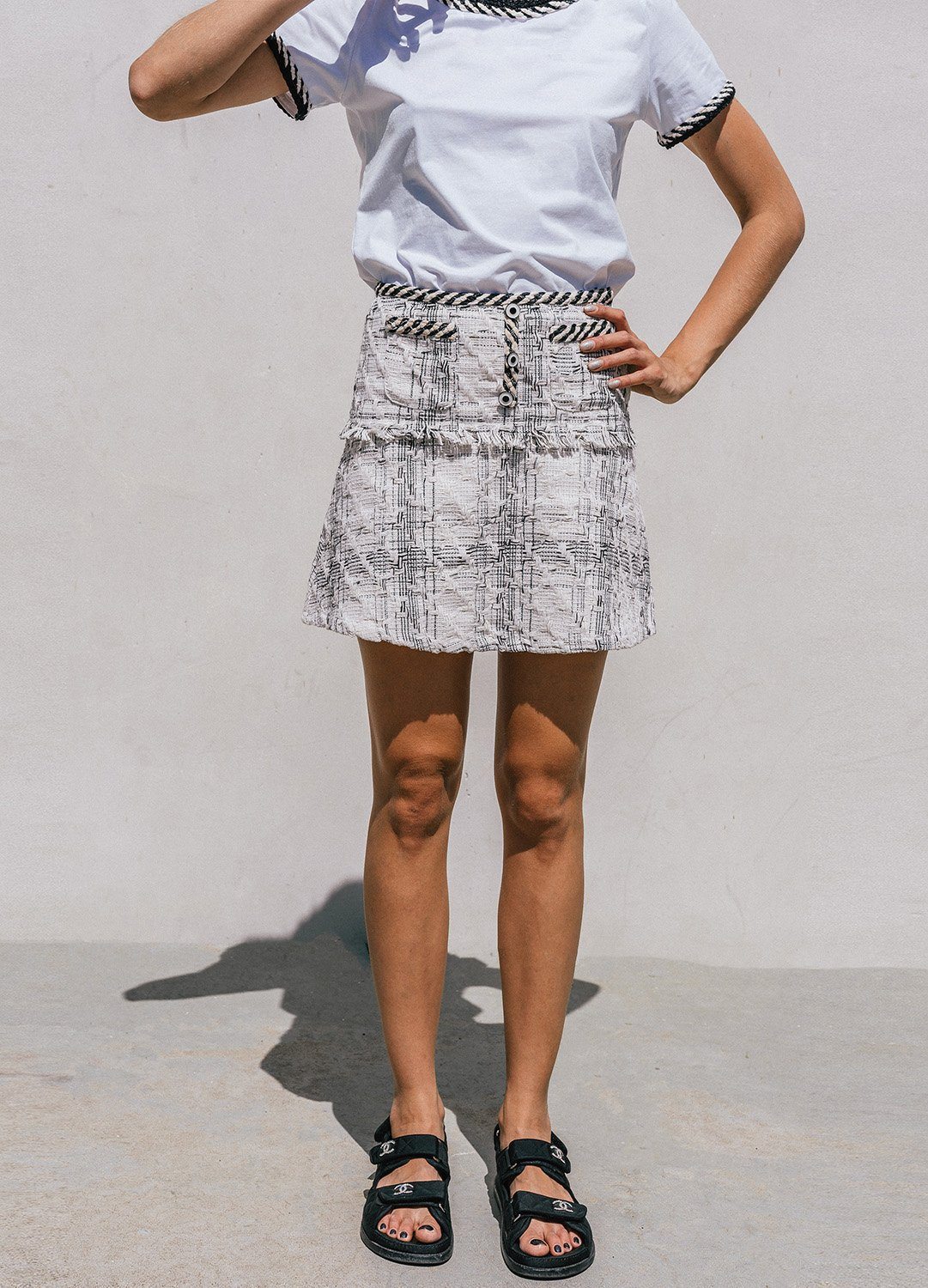 Ambre Tweed Mini Skirt featuring a chic pattern and patch pockets, styled with a white T-shirt.