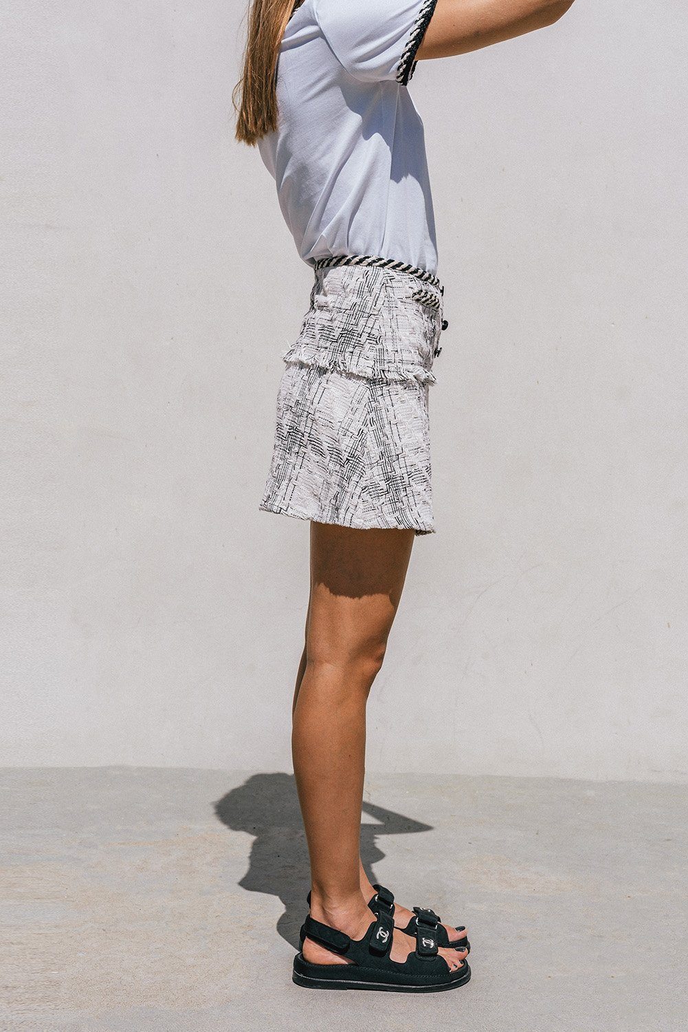 Ambre Tweed Mini Skirt featuring a chic pattern and patch pockets, styled with a white T-shirt.