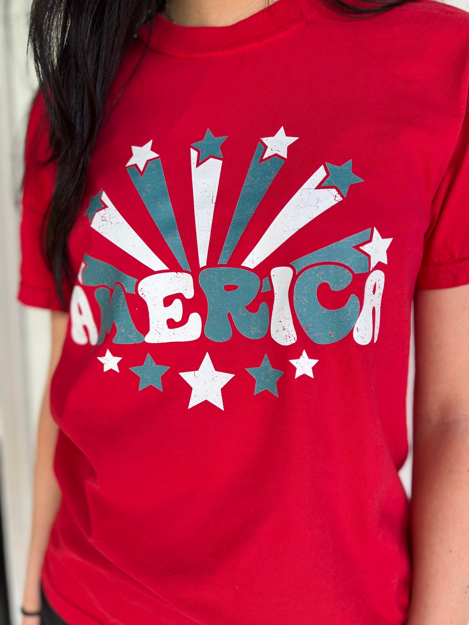 A vibrant red America Stars Tee featuring a patriotic design, perfect for 4th of July celebrations.