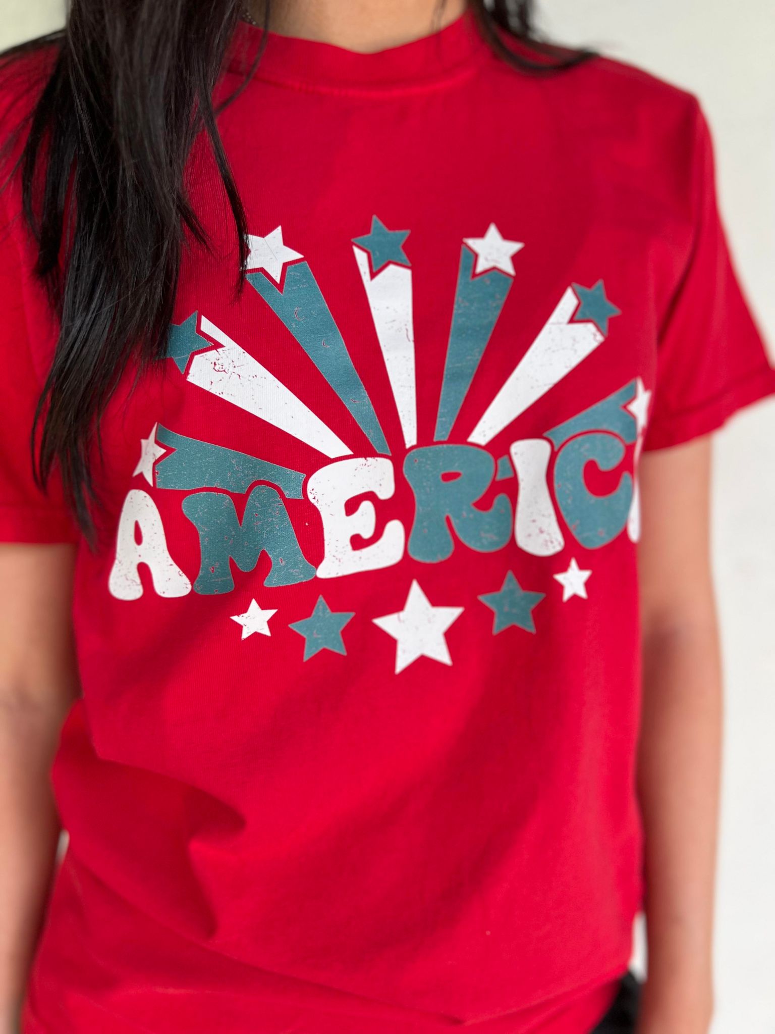 A vibrant red America Stars Tee featuring a patriotic design, perfect for 4th of July celebrations.