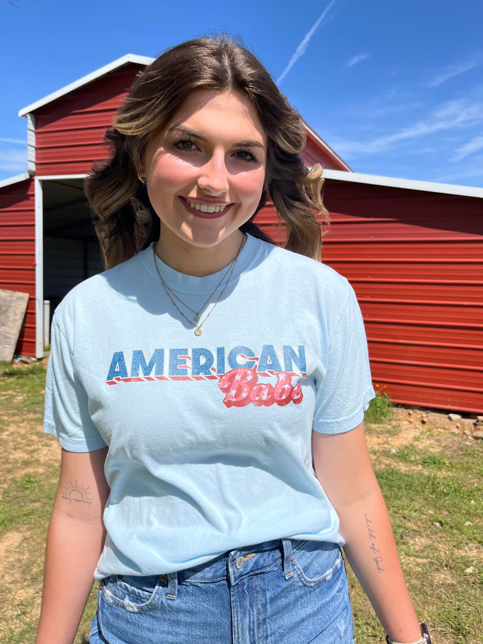 A soft, 100% cotton American Babe Tee in Chambray color, featuring a vibrant DTF printed design, perfect for 4th of July celebrations.