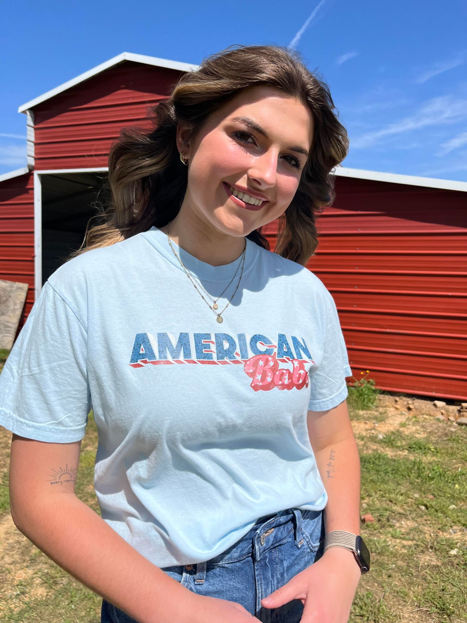 A soft, 100% cotton American Babe Tee in Chambray color, featuring a vibrant DTF printed design, perfect for 4th of July celebrations.