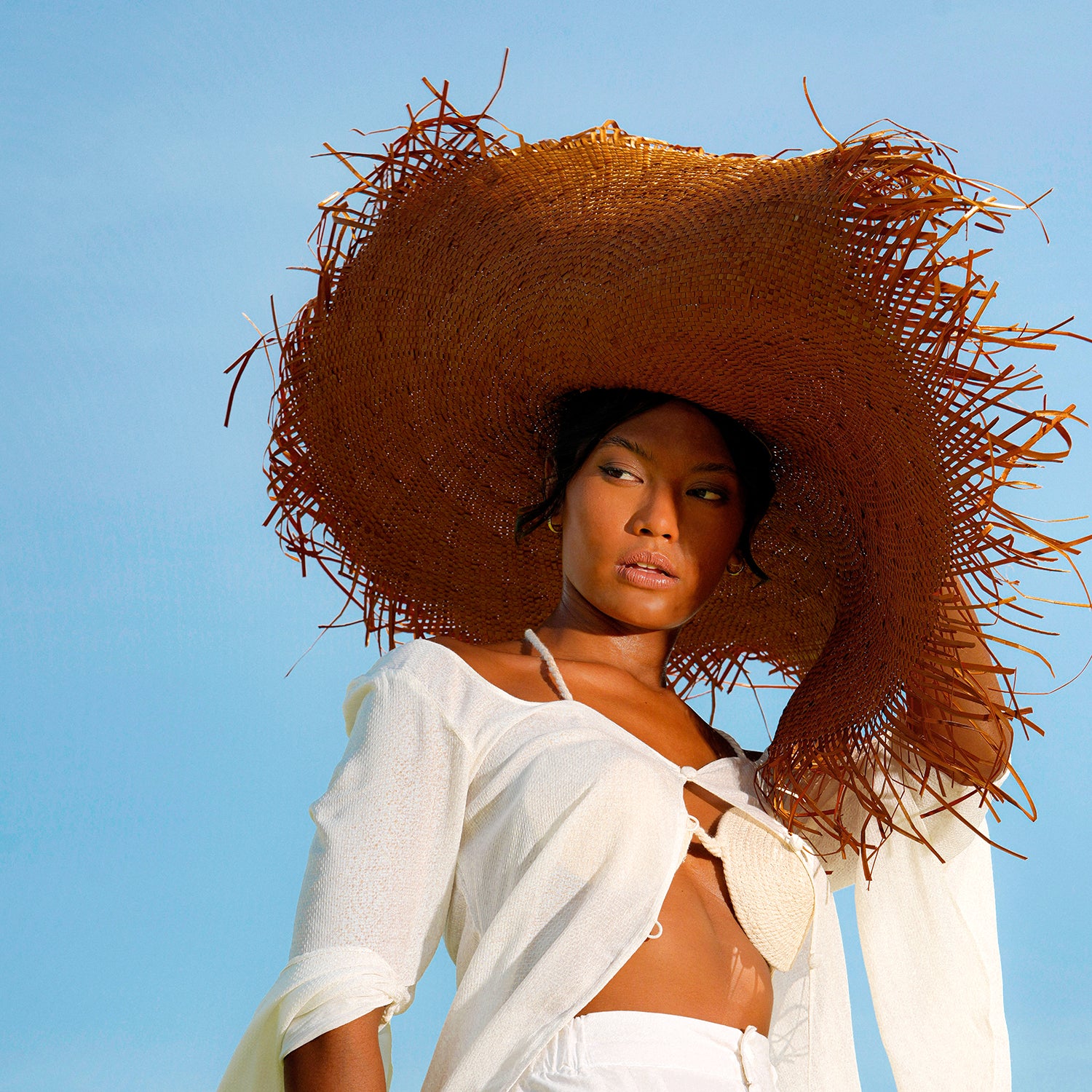 AMORA Oversized Woven Straw Hat in Chestnut Brown with frayed edges and wide brim, perfect for summer sun protection.