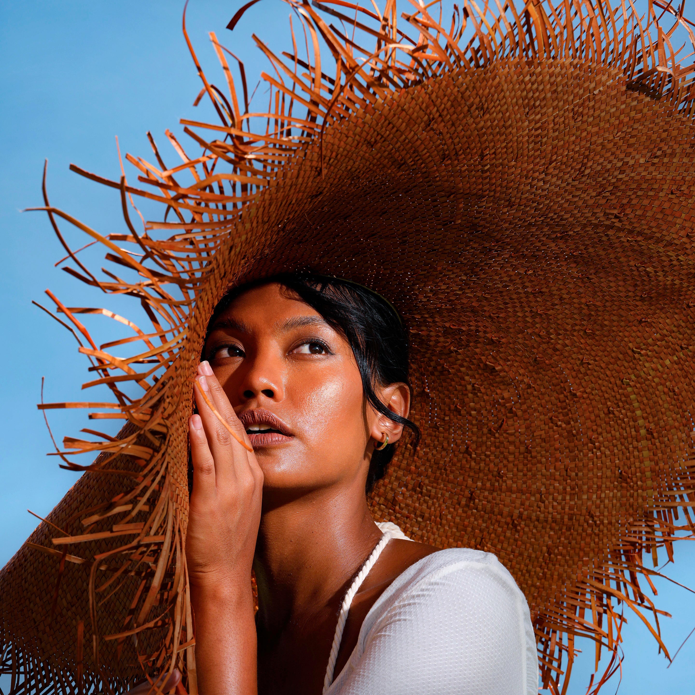 AMORA Oversized Woven Straw Hat in Chestnut Brown with frayed edges and wide brim, perfect for summer sun protection.