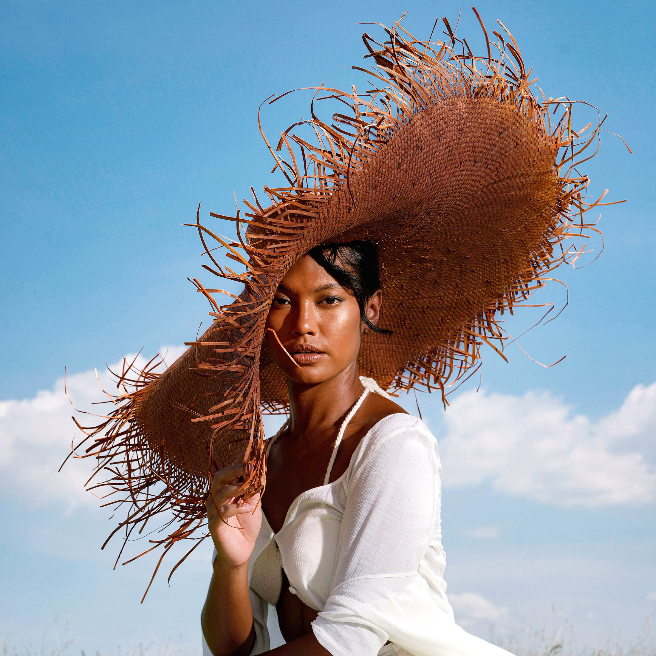 AMORA Oversized Woven Straw Hat in Chestnut Brown with frayed edges and wide brim, perfect for summer sun protection.