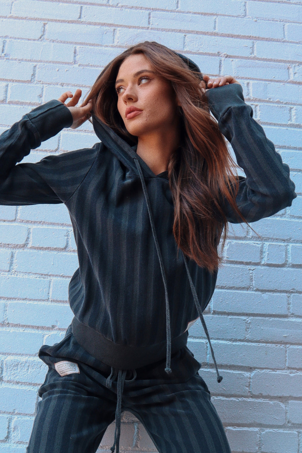 Amore Hoodie in black, showcasing its cropped design and lightweight organic cotton fabric, perfect for casual outings.