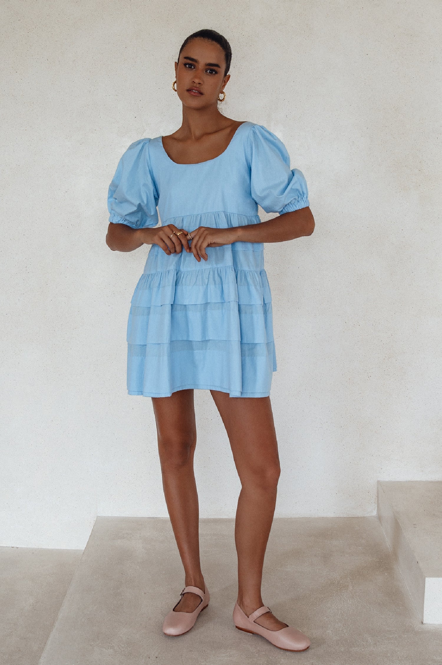 A stylish Andrea Babydoll Cotton Mini Dress featuring elasticated short sleeves, a round neckline, and a flowing hem, perfect for casual or evening wear.