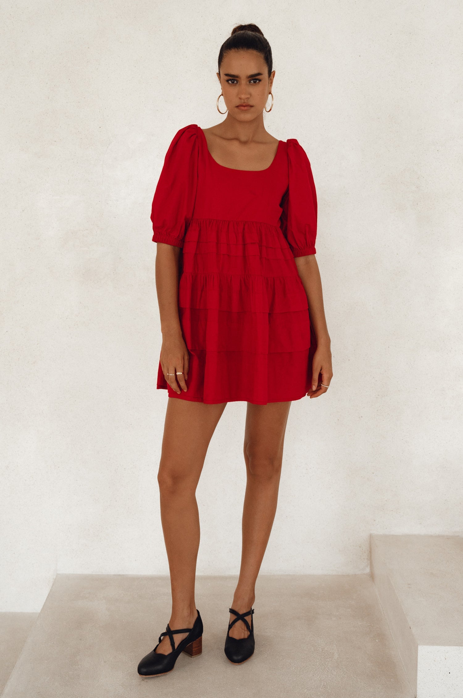 A stylish Andrea Babydoll Cotton Mini Dress featuring elasticated short sleeves, a round neckline, and a flowing hem, perfect for casual or evening wear.