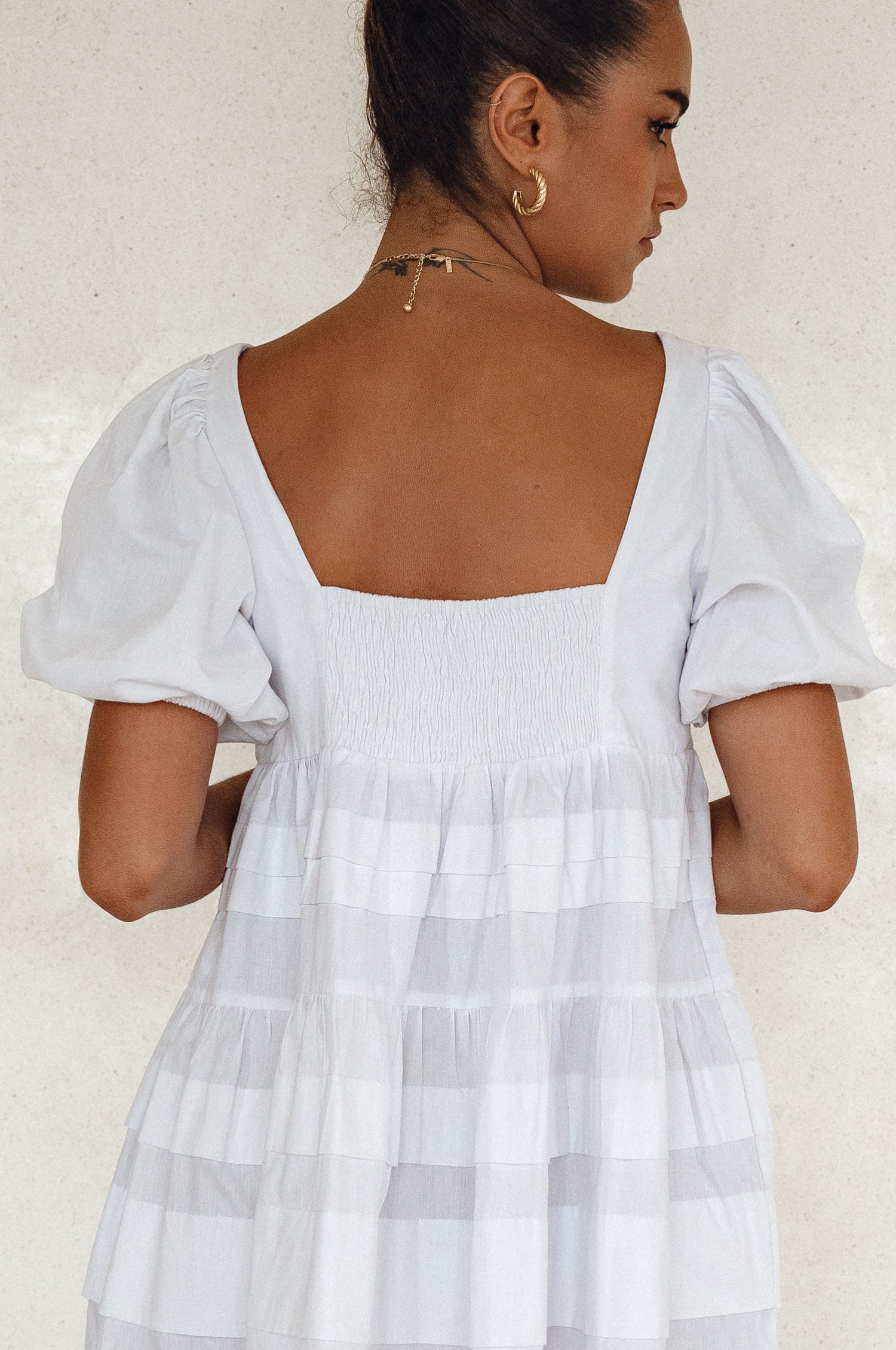 A stylish Andrea Babydoll Cotton Mini Dress featuring elasticated short sleeves, a round neckline, and a flowing hem, perfect for casual or evening wear.