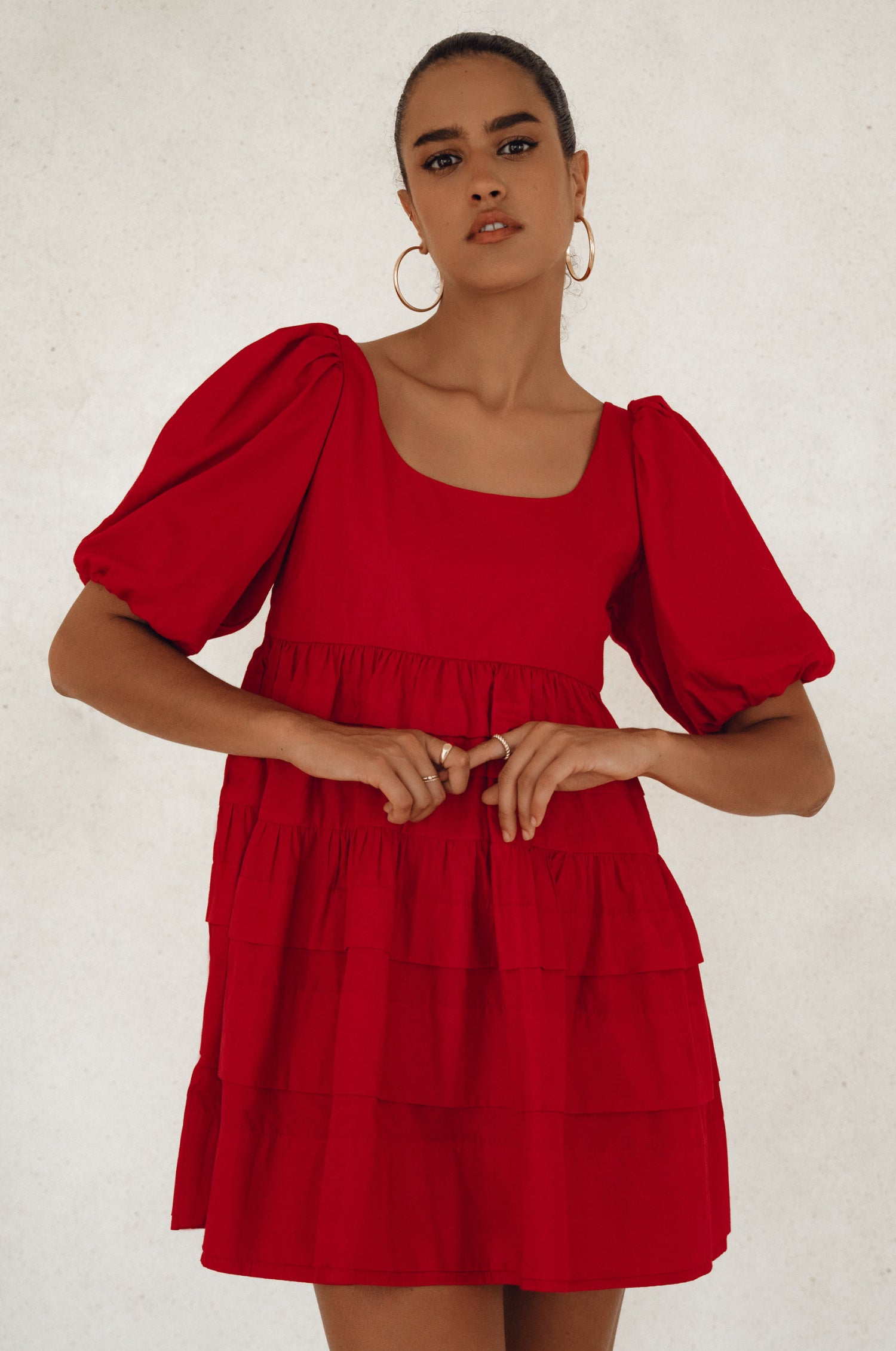 A stylish Andrea Babydoll Cotton Mini Dress featuring elasticated sleeves and a round neckline, made from breathable poplin cotton.