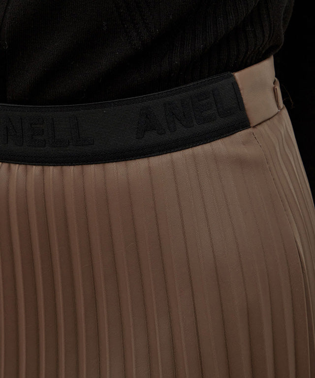 Anell Golf Bold Pleated Skirt in Brown, showcasing luxurious suede-combined leather with abundant pleats and a stylish design.