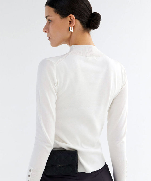 Anell Golf Classic Slim Knit Top in Ivory featuring a turtleneck and diagonal design details.