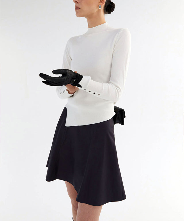 Anell Golf Classic Slim Knit Top in Ivory featuring a turtleneck and diagonal design details.