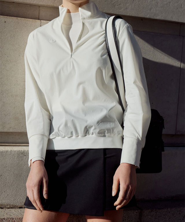 Anell Golf Classic Slim Knit Top in Ivory featuring a turtleneck and diagonal design details.